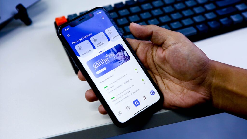 Pessoa segurando um smartphone com o aplicativo beFranq aberto, ferramenta usada por Personal Bankers para enviar propostas, acompanhar operações financeiras e mais!