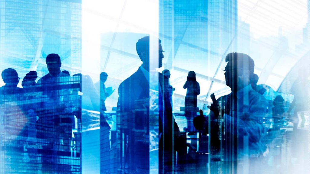Silhuetas de executivos em ambiente corporativo, representando negociação de linha de crédito para empresas.