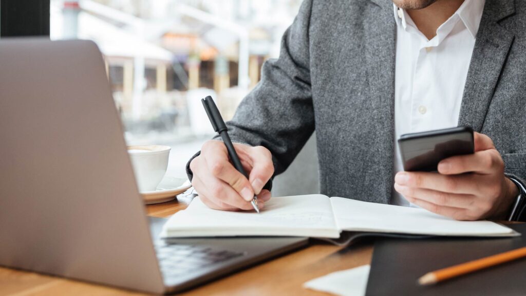 Profissional analisando dados financeiros e fazendo anotações em um caderno, representando o levantamento inédito da Franq.